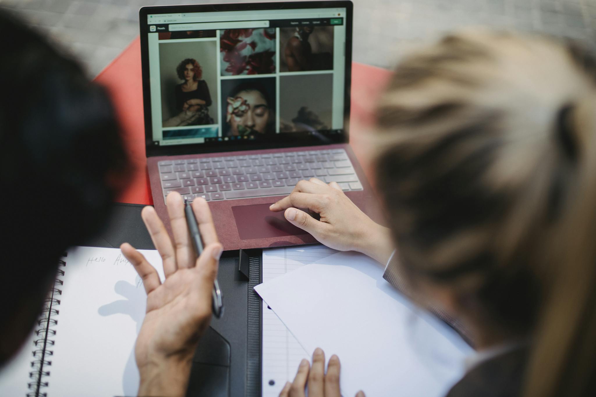 Person Using Laptop on Red Table